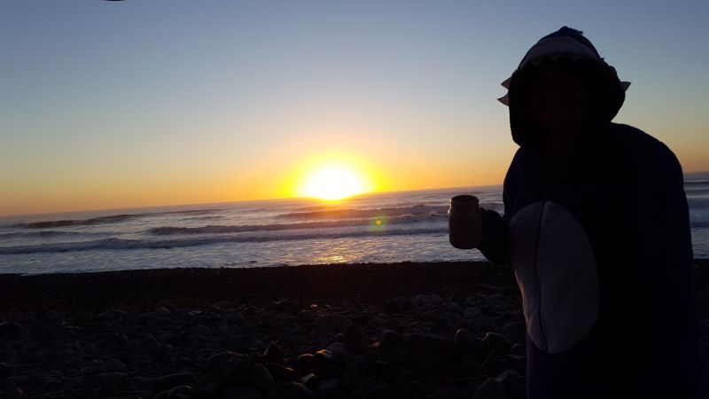 Vivre un lever du soleil sur la mer avec un café